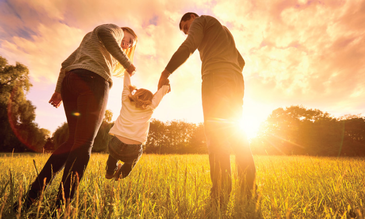 family playing together at sunset